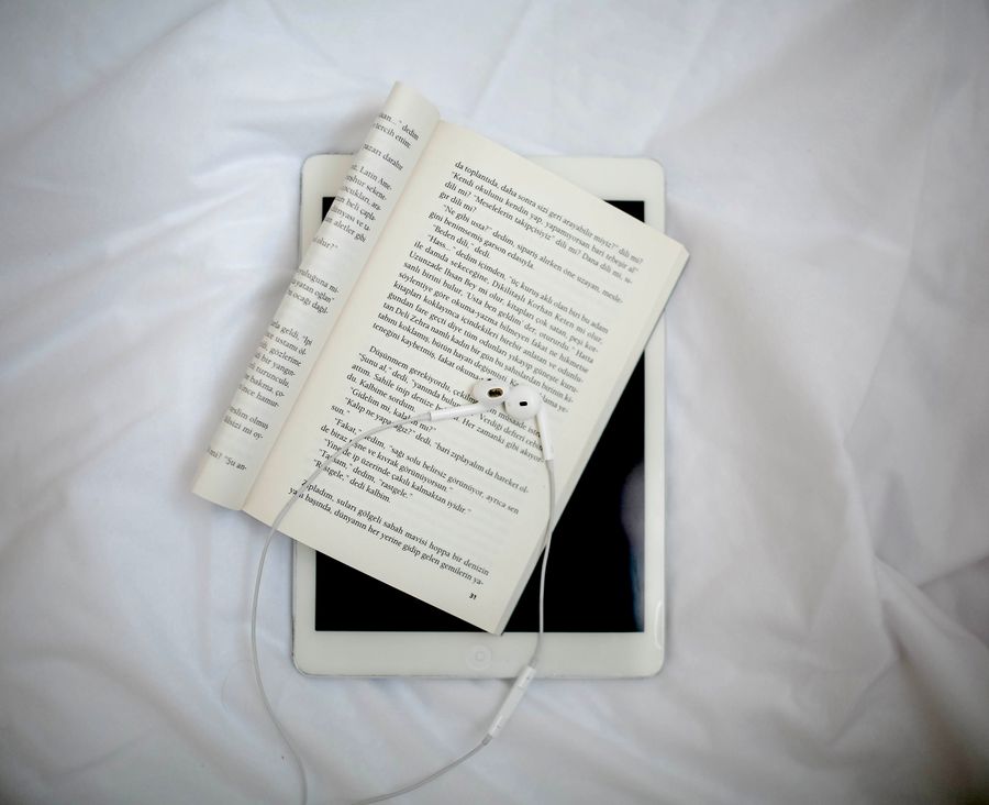 Libro abierto con auriculares para estudio digital